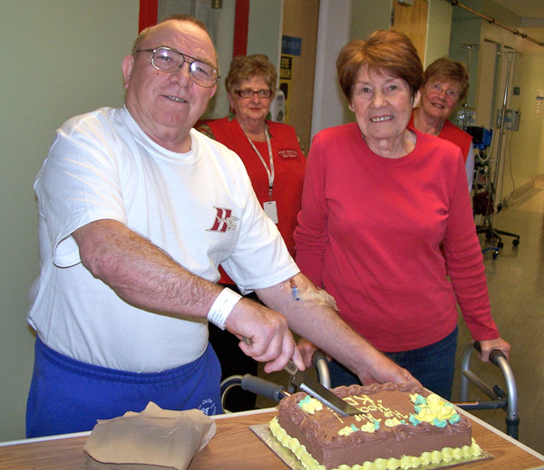 The first two hip replacement patients at KDH: Bryne Nuttall (left) and Maureen Mindach cut a celebratory cake while KDH Auxiliary volunteers Catherine Brunton (left) and Louise Tallman look on