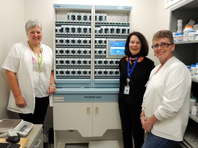Pharmacy staff (l. to r.) Cindy Kerkhof, Mary Whyte and Karen Schipper have worked tirelessly to help implement new EMR technologies including this PACMED machine, which packages, labels and barcodes individual patient medication doses.