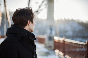 Youth standing on the bridge looking away